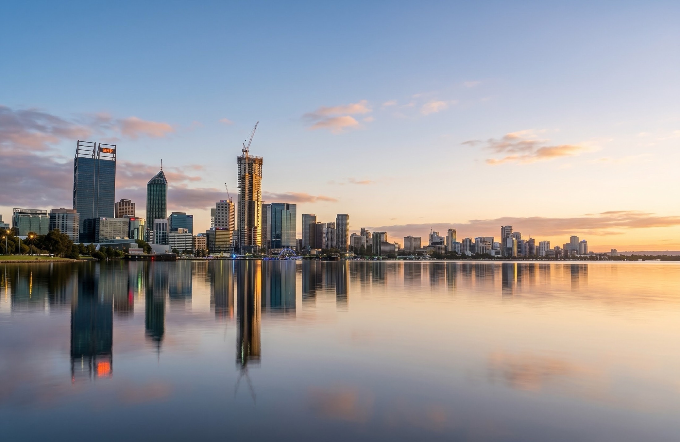 The Perth CBD skyline reflected across the Swan River at dusk